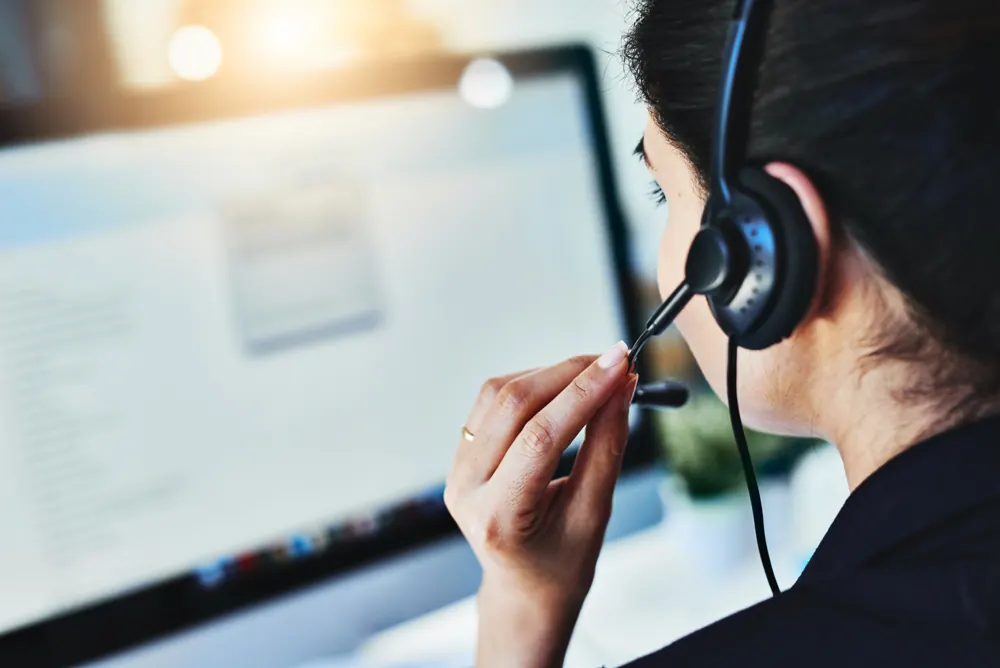 A support specialist with a headset working at a laptop